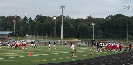 Patriots football team playing in a game in 2018. Current players and coaches are hopeful for the chance to play this school year.
