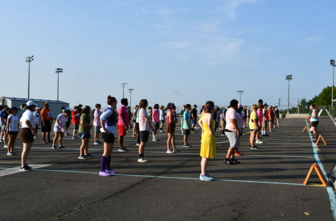 The band members are all lined up on the drivers ed lot at the beginning of band camp.
