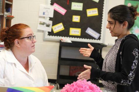 Gen Z Patriot High School student, Ravnoor Munjal, discusses after-school activities in a classroom with
her teacher Ms. Frame.