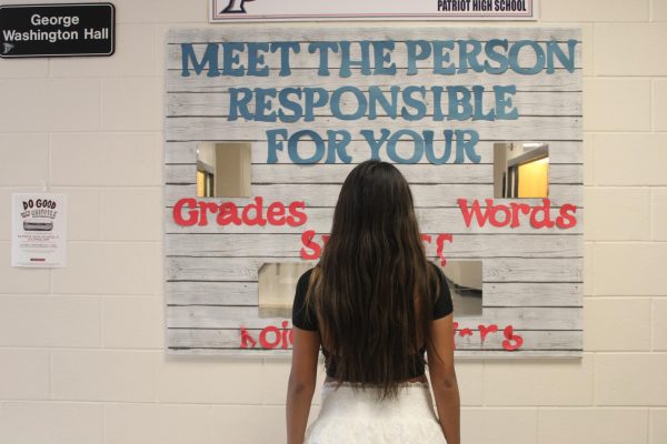 Bri Bacamante (‘25) viewing herself in the infamous mirror wall at Patriot High School. The mirror wall is a spot for students to simultaneously look at themselves and to reconnect with their goals. Many stop to check their outfit, making sure they feel confident and ready to work toward their goals for the day. 