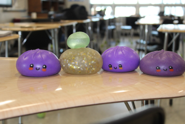 This photo is Megan Bergeron's collection of RMS dumplings which includes three purple, one glitter, and one green mini dumpling. This photo was taken by Leila Strawn on April 15, 2026, at Patriot High School.